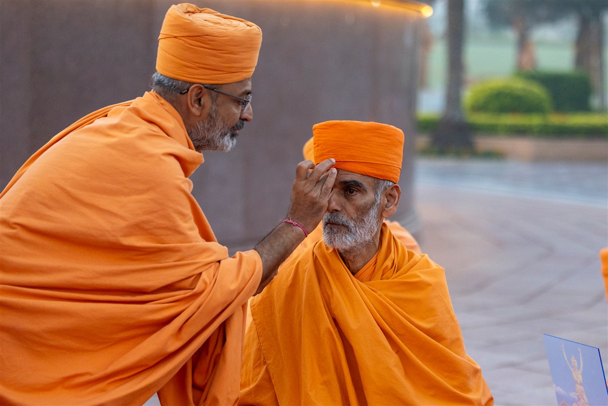 Munivatsal Swami applies a chandlo to Anandswarup Swami