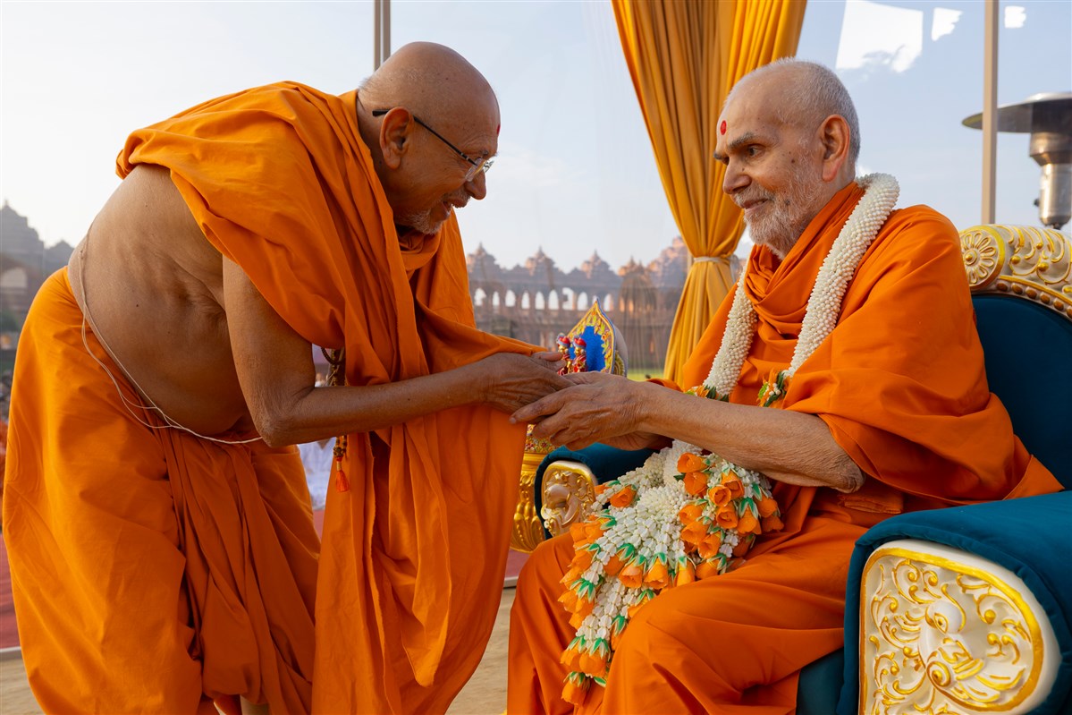 Pujya Tyagvallabh Swami honors Swamishri with a garland