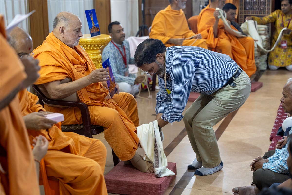 Pujya Ishwarcharan Swami presents a memento to a volunteer