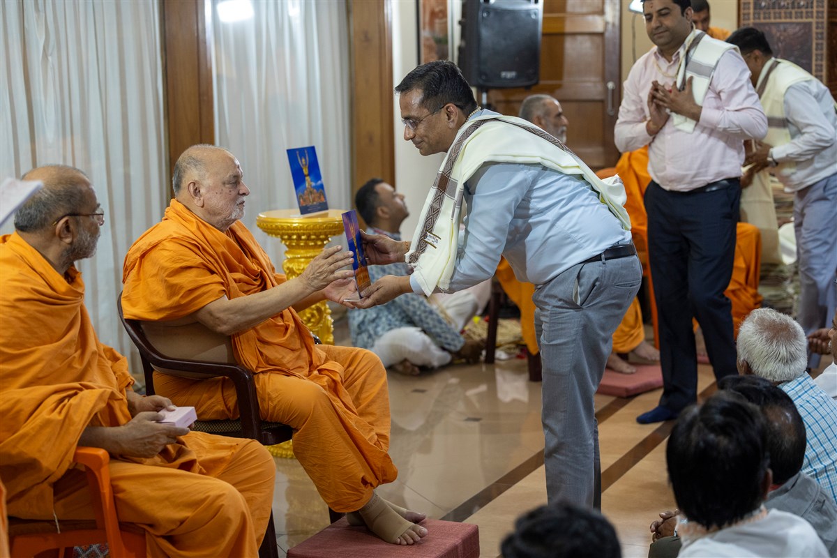 Pujya Ishwarcharan Swami presents a memento to a volunteer