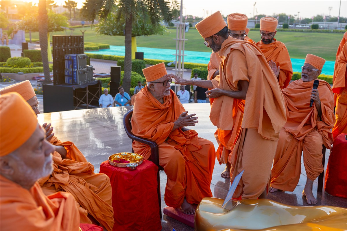 Manovijay Swami applies a chandlo to Pujya Kothari Swami