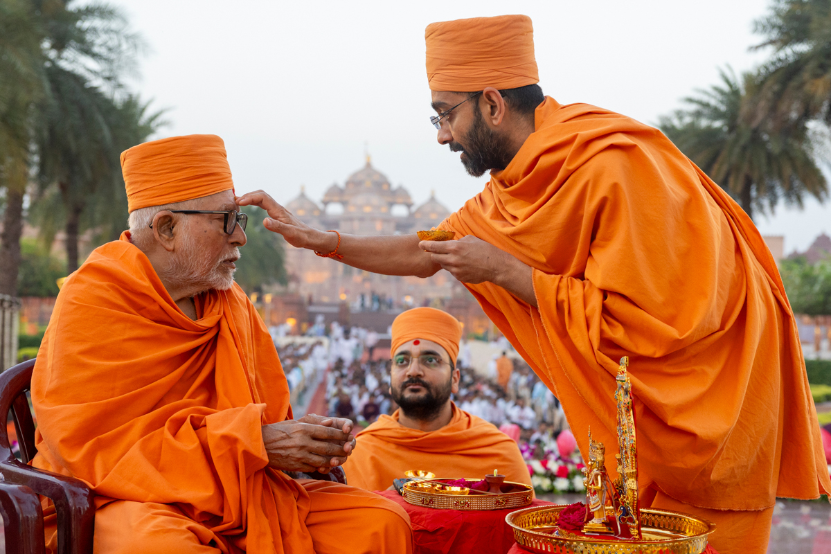 A swami applies a chandlo to Pujya Kothari Swami