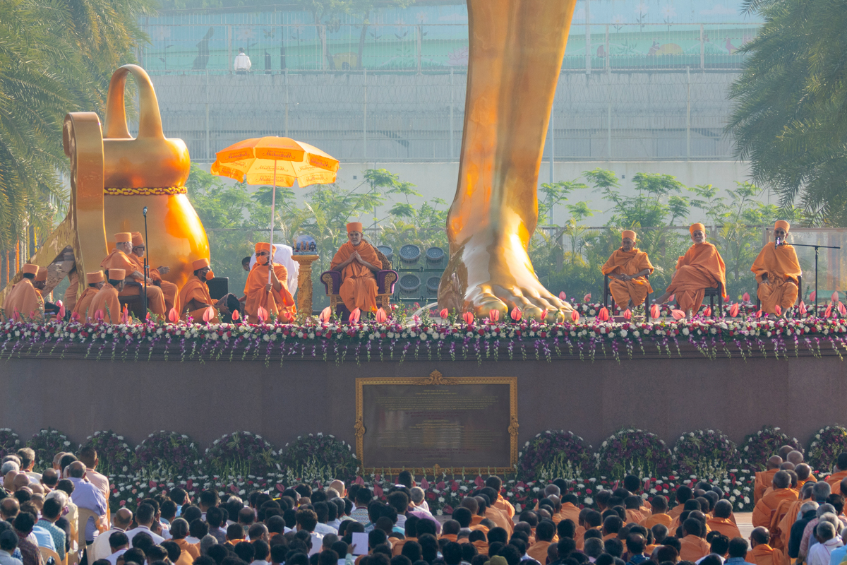 Swamishri and senior swamis seated on the plinth of Tapomurti Shri Nilkanth Varni's murti