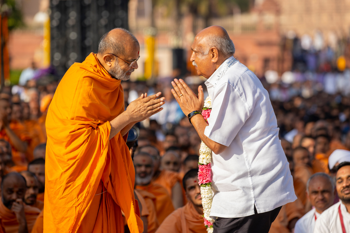 Gnaneshwar Swami honors a devotee with a garland