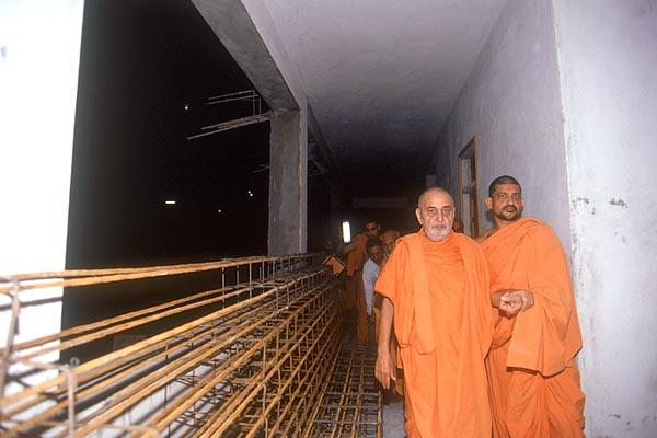 Swamishri observes the ongoing construction of the residential complex for pilgrims
