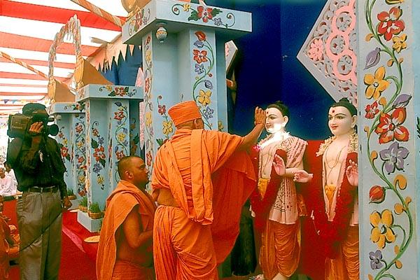 Swamishri applies kumkum and rice grains as part of the pujan rituals to Shri Akshar Purushottam Maharaj ...