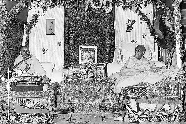 Yogiji Maharaj listens to the parayan delivered by Pramukh Swami Maharaj