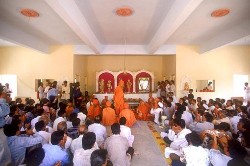 Pratishtha arti being performed by Swamishri and devotees