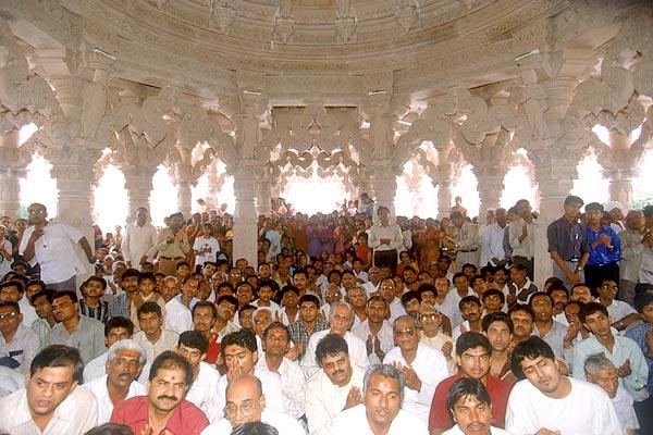 Devotees doing darshan during arti beneath the mandir dome