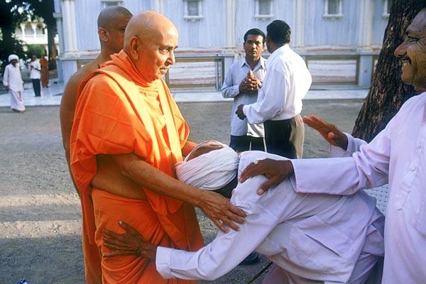 Swamishri patiently enquires the wellbeing of an aged devotee and blesses him  Swamishri patiently enquires the wellbeing of an aged devotee and blesses him  