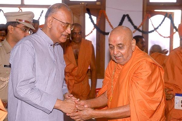 Swamishri welcomes and offers a gift to the Governor Shri Dineshnandan Sahay