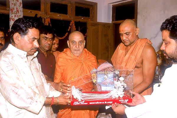 The Mayor of Raipur Shri Tarun Chatterjee presents a gift to Thakorji and Swamishri