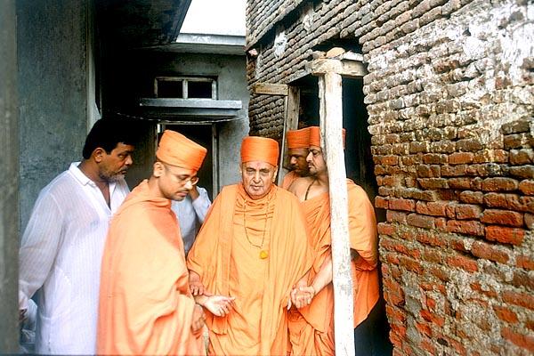Swamishri sanctifies and observes the newly acquired homes adjacent to the Smruti Mandir 