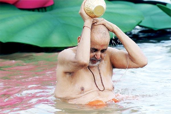 Swamishri bathing in the river Utavali
