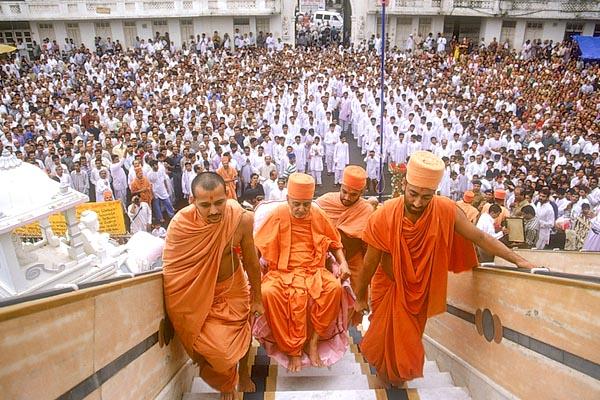 Swamishri being taken up the mandir steps for Thakorji's darshan 