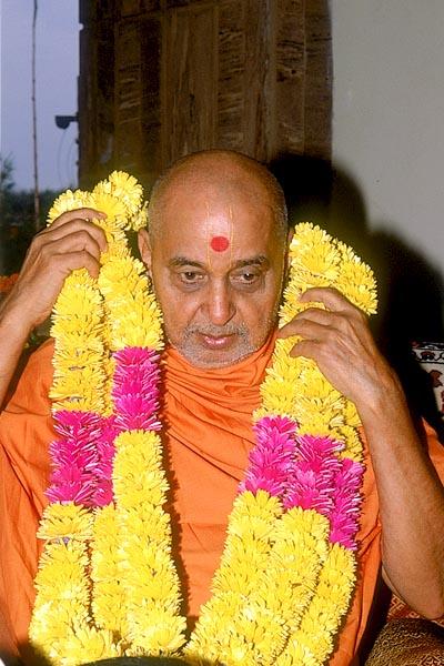 Swamishri is garlanded after puja