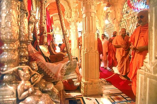 Swamishri gently rocks Thakorji in a hindolo 