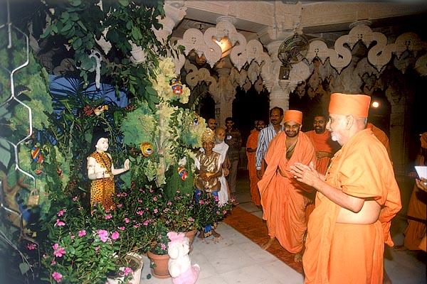 Swamishri engaged in darshan of a similar recreation of Nilkanth's forest travels beneath the mandir dome