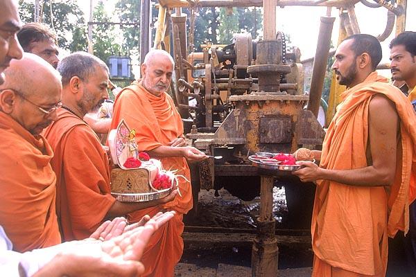 Swamishri offers pujan for a borewell by BAPS for the citizens of Mahelav