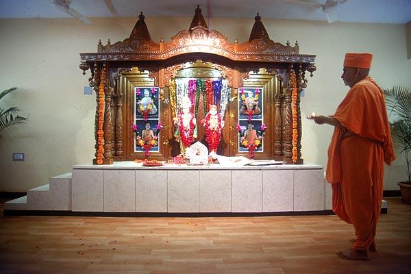 Swamishri performs arti of Thakorji in the hostel's prayer hall