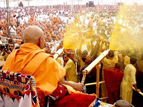The crowning glory of the festival - Swamishri sprays the sanctified colored water on the elated devotees 