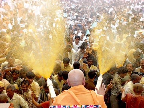The crowning glory of the festival - Swamishri sprays the sanctified colored water on the elated devotees 
