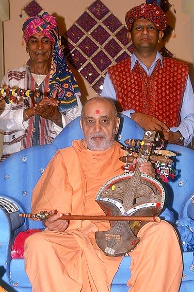 Swamishri holds Surando, Ravan Haththo and other instruments as the artistes enjoy a photo session with Swamishri 