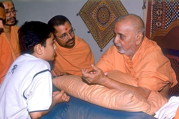 Swamishri meets, listens to, advises and blesses a local balak 