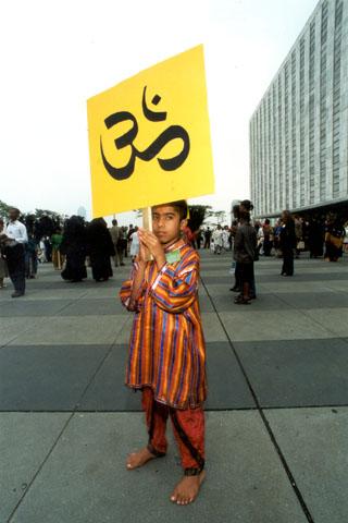 A child welcoming the Hindu delegates with the symbol of 'Om'