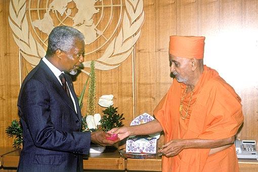Swamishri offers a flower sanctified by Lord Harikrishna Maharaj to H.E. Kofi Annan