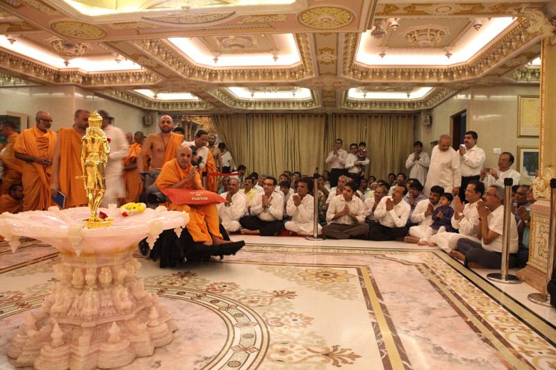 Swamishri engaged in darshan of Shri Nilkanth Varni (abhishek murti)