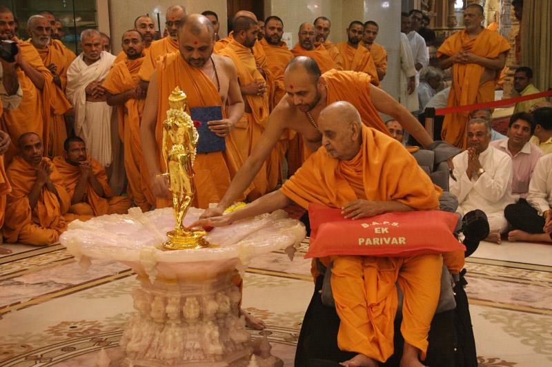 Swamishri engaged in darshan of Shri Nilkanth Varni (abhishek murti)