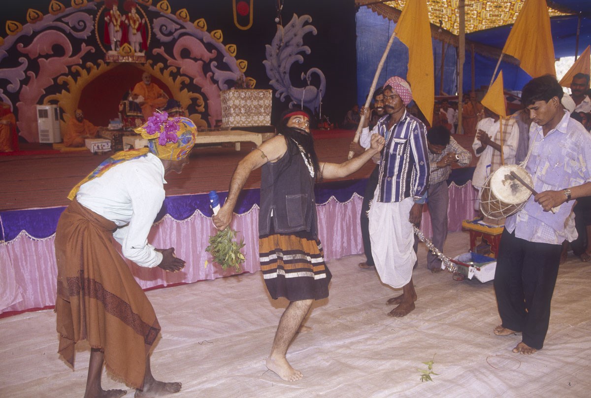Tribal devotees perform a skit presentation in the assembly