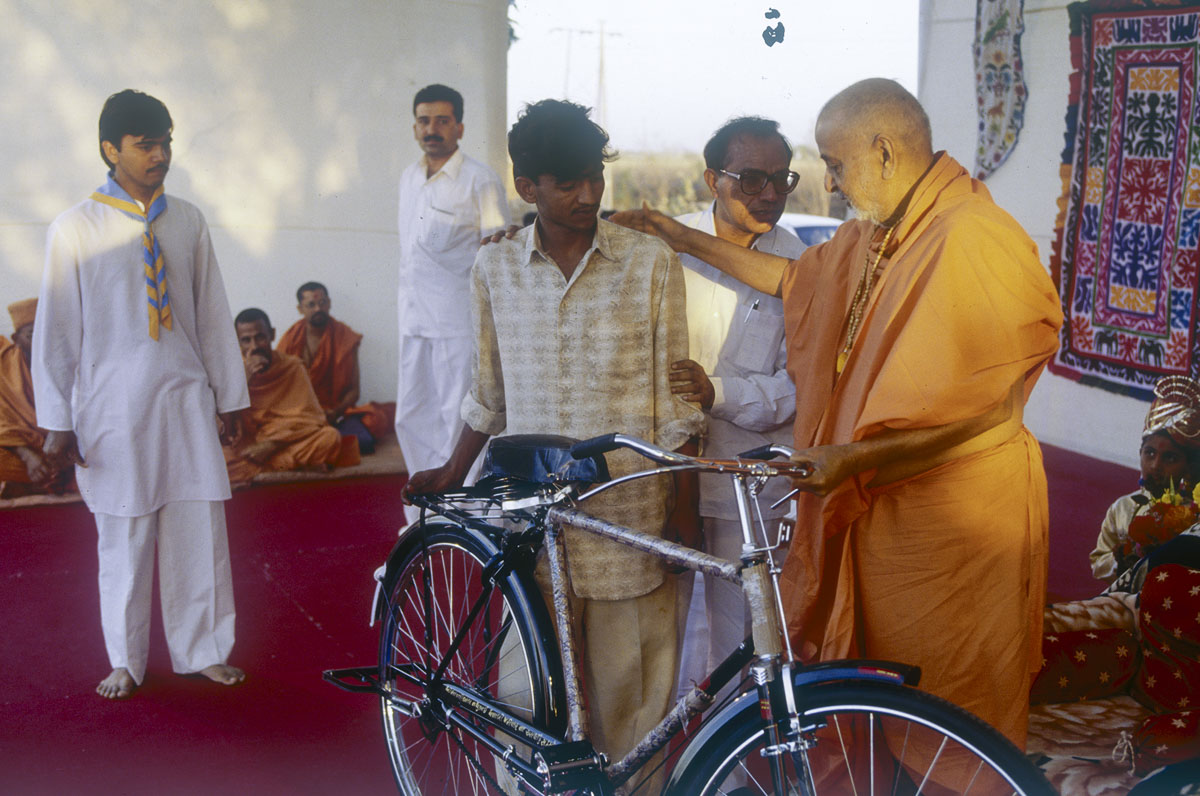 Swamishri gives a bicycle to a well-wisher
