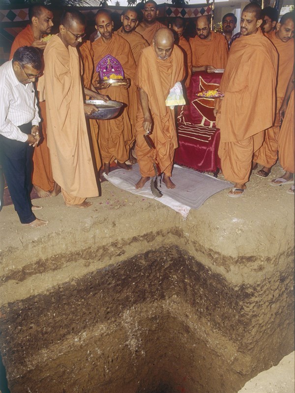 Swamishri pours cement in the pillar base