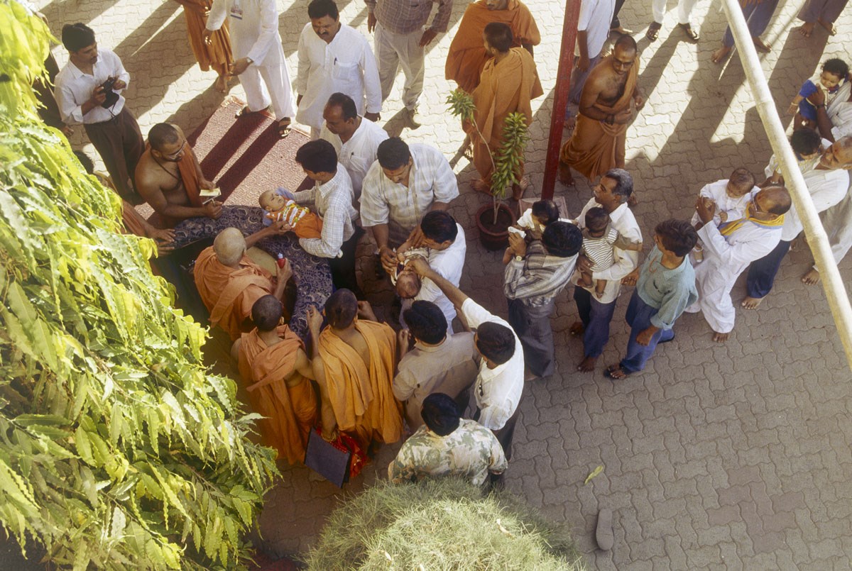 Swamishri gives vartaman to children and devotees