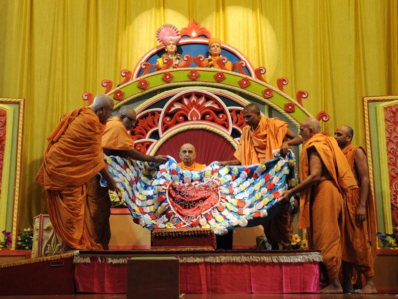 Sadhus honor Swamishri with shawl and garlands