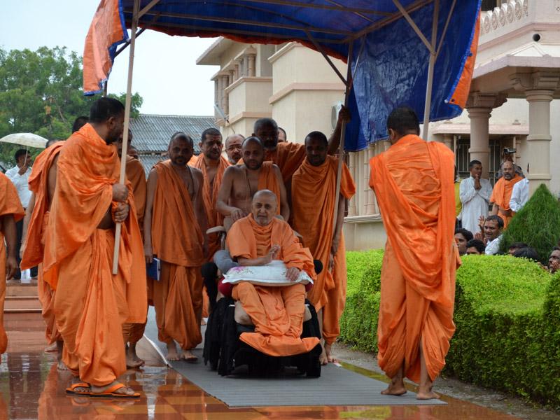 In the monsoon rains Swamishri goes for Thakorji's darshan. Devotees, after faithfully waiting in the rain, are overjoyed with Swamishri's darshan and blessings