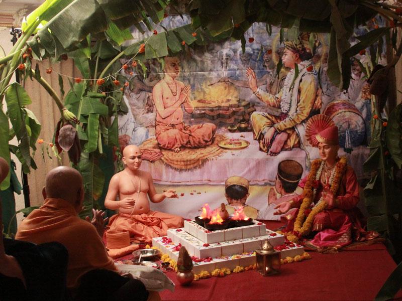 Swamishri engaged in darshan of a diorama depicting Shri Gunatitanand Swami's diksha, on Poshi Punam