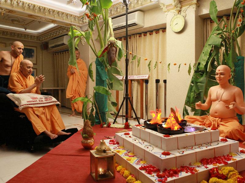 Swamishri engaged in darshan of a diorama depicting Shri Gunatitanand Swami's diksha, on Poshi Punam 