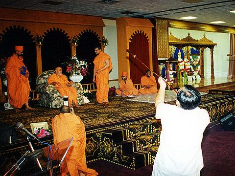 Devotees receiving Swamishri with traditional pipes