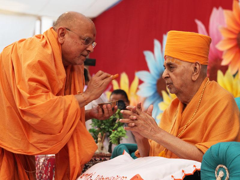  Pujya Ishwarcharan Swami performs chandan archa on the forehead of Swamishri