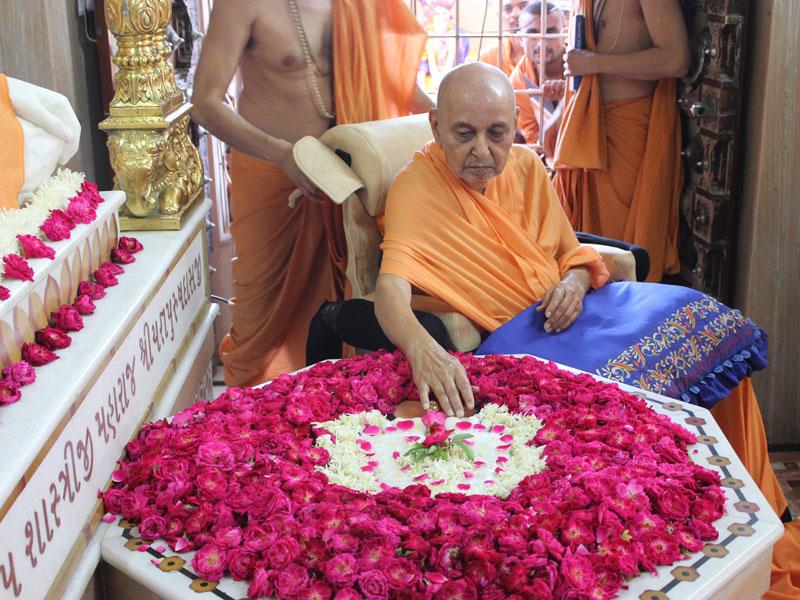 Swamishri reverentially touches holy charnarvind of Bhagwan Swaminarayan 