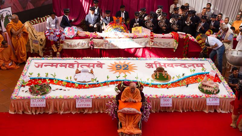  Swamishri greets devotees with 'Jai Swaminarayan' in front of the large decorated cake