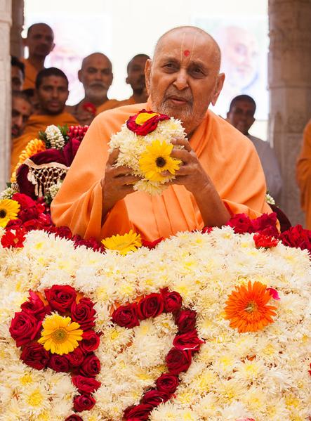  Swamishri holds a ball of flowers