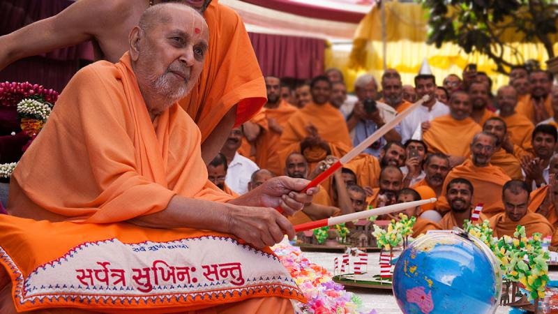 Swamishri plays drum sticks on the cake decorations