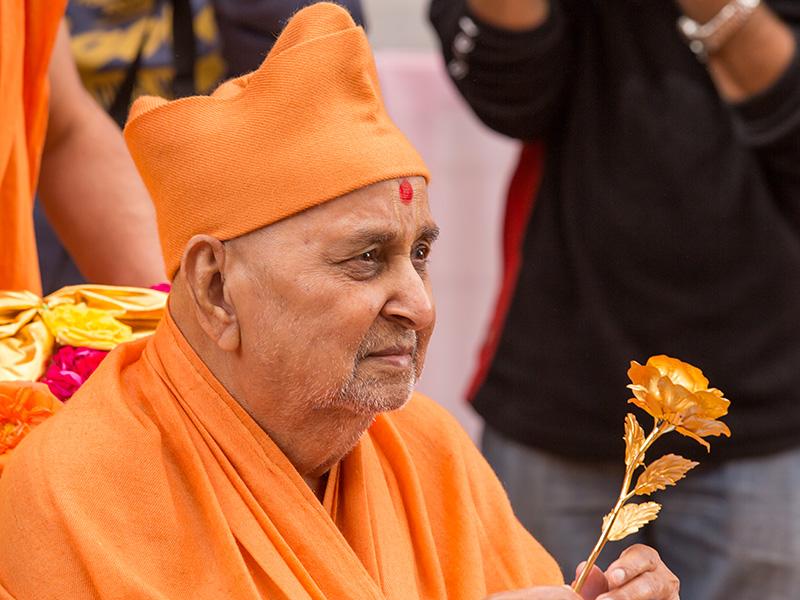  Swamishri sanctifies a decorative flower 