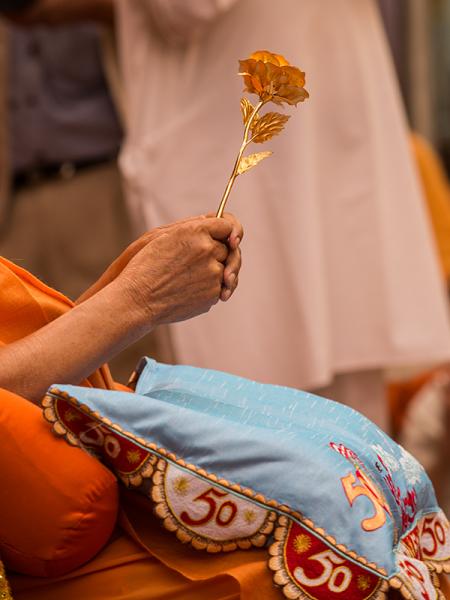  Swamishri sanctifies a decorative flower
