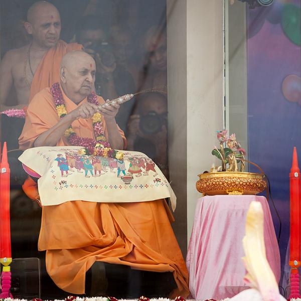  Swamishri sprays colored water on Shri Harikrishna Maharaj