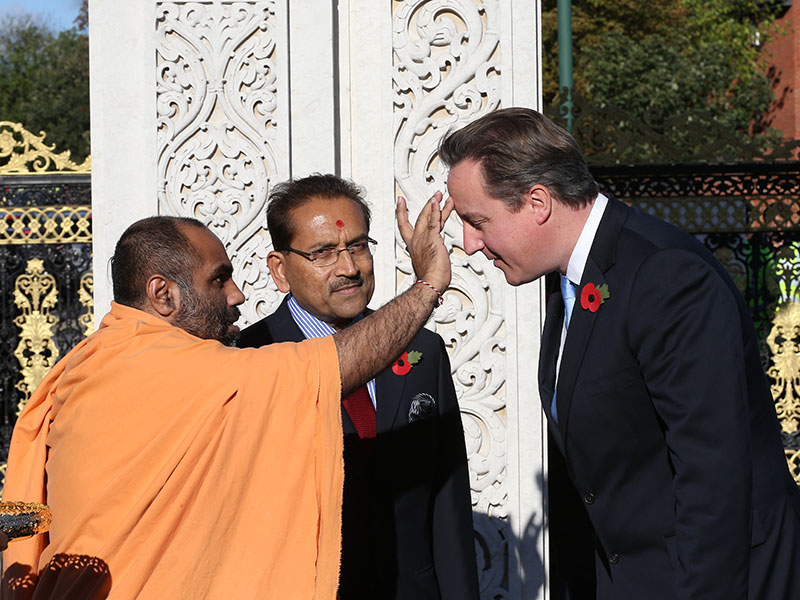 British Prime Minister David Cameron is greeted traditionally on arrival at the London Mandir